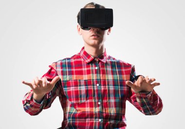 Ekose desenli gömlek gri arka plan karşı sanal kask giymiş genç adam