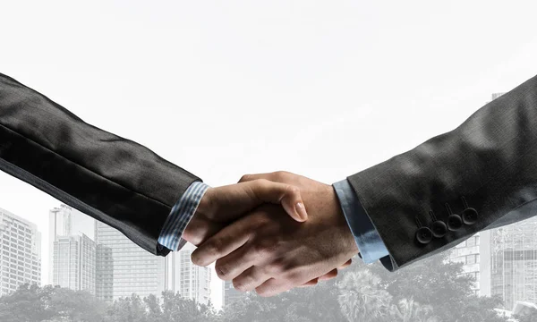 Business handshake as idea for unity and cooperation or greeting. Mixed media — Stock Photo, Image