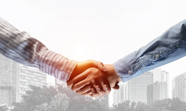 Business handshake as idea for unity and cooperation or greeting. Mixed media — Stock Photo, Image