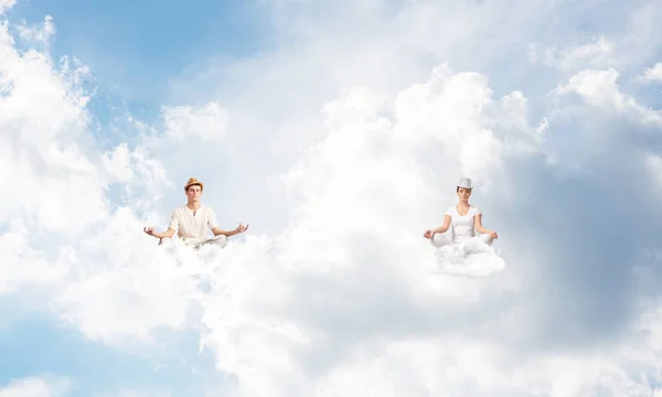 年轻夫妇保持眼睛闭上 看着集中 而冥想云在空气中多云影像背景 — 图库照片