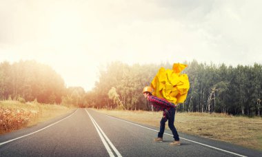 Sırtında kağıt top taşıyan inşaatçı.