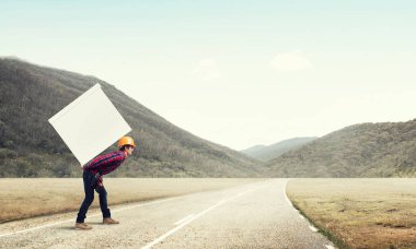 Adam büyük kutusunu sırtında taşıyor.