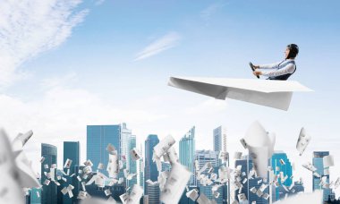 Havacı bulutlu mavi gökyüzünde iş merkezi üzerinde kağıt uçak sürüş. Gökdelenlerin arka planına düşen kağıtlar. Deri kasklı pilot kağıt düzlemde otururken ve direksiyonu tutarak.