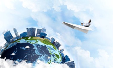 Komik havacı kağıt düzlemde oturan ve direksiyon tutan. Bulutlu mavi gökyüzünde kağıt uçak kullanan pilot. İş bölgesinde yüksek gökdelenler ile modern şehrin küresel görünümü.