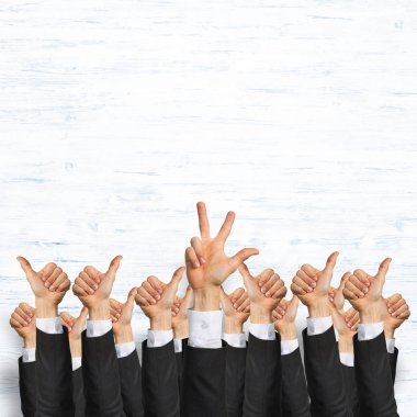 Bir grup iş adamı ahşap arka planda jestler gösteriyor.