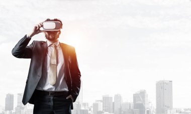 Genç yakışıklı iş adamı cityscape arka plan karşı sanal kask