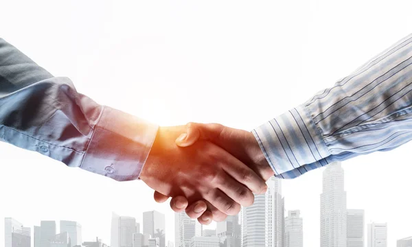 Business handshake as idea for unity and cooperation or greeting. Mixed media — Stock Photo, Image