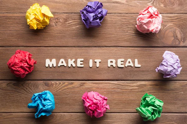 Faire une vraie phrase sur une table en bois et des boules de papier autour — Photo