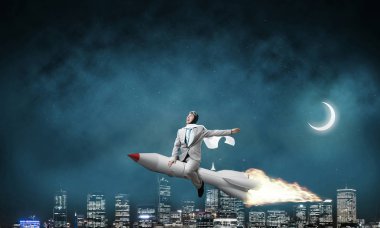 Arka plan üzerinde gece cityscape ve mavi gökyüzü ile roket üzerinde uçan takım elbiseli genç işadamı kavramsal görüntü.