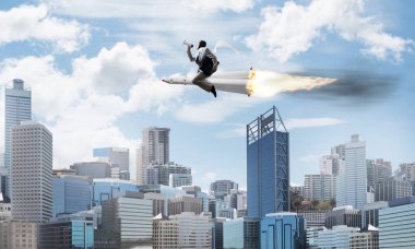 Arka plan üzerinde modern cityscape gökdelenler ve mavi gökyüzü ile roket üzerinde uçan takım elbiseli genç işadamı kavramsal görüntü.