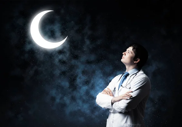 背景に暗い宇宙空間で立っている間 若い月と相互作用する若くてプロの男性医師の水平ショット — ストック写真
