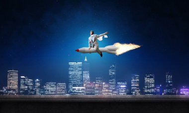 Arka plan üzerinde gece cityscape ve mavi gökyüzü ile roket üzerinde uçan takım elbiseli genç işadamı kavramsal görüntü.