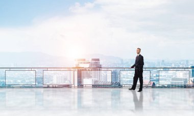 Gökdelenlerin üzerinde gün doğumu ve yeni bir güne bakan iş adamı
