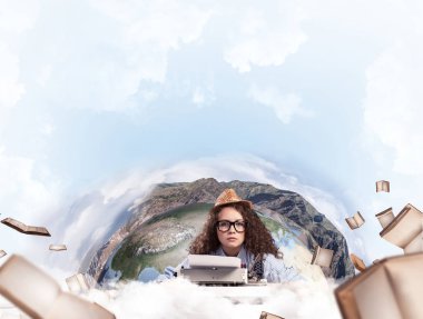 Portrait of hard-working female writer using typing machine while sitting at the table with flying papers and Earth globe among cloudy skyscape on background. Elements of this image furnished by NASA