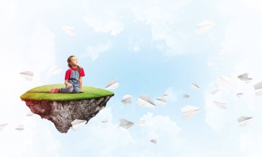 Gökyüzünde yüzen bir adada oturan tatlı, gülümseyen bir kız.