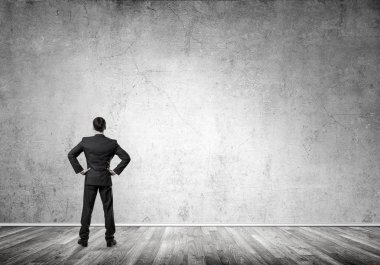 Boş beton odada kendine güvenen zarif iş adamının arka planı