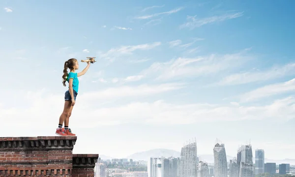 可爱快乐的孩子女孩在建筑顶部玩复古飞机模型 — 图库照片