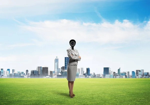 Macchina fotografica diretto donna in piedi su erba verde contro paesaggio urbano moderno — Foto Stock