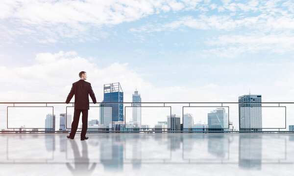 Sunrise above skyscrapers and businessman facing new day