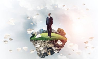 Mavi gök yeşil yüzen ada üzerinde duran zarif emin iş adamı