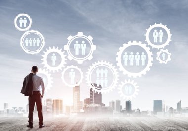 Modern şehir manzarası ve vites bağlantısı fikrine bakan işadamlarının arka planı