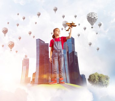 Şehrin yüzen adasında eski model uçaklarla oynayan tatlı bir kız.