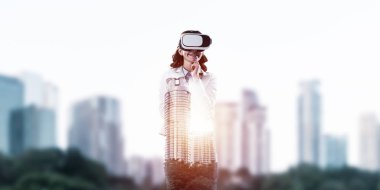 Sanal gerçeklik gözlüğü ve modern şehir manzarası takan iş kadınının çifte pozu.