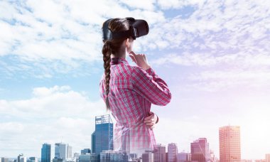 Sanal gerçeklik kaskı takmış beyaz bir kadın şehrin arka planına karşı