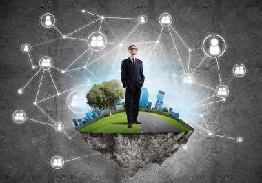 Uçan yeşil adada beton zeminde zarif bir işadamı.