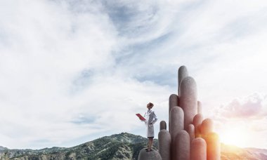 Genç kadın doktor eller satnding taş sütun alanındaki klasörle