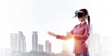 Sanal gerçeklik kaskı takmış beyaz bir kadın şehrin arka planına karşı