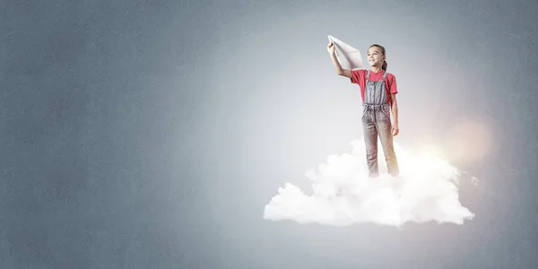 かわいいです女の子立って雲と紙飛行機を投げる — ストック写真