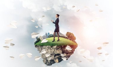 Mavi gök yeşil yüzen ada üzerinde duran zarif emin iş kadını