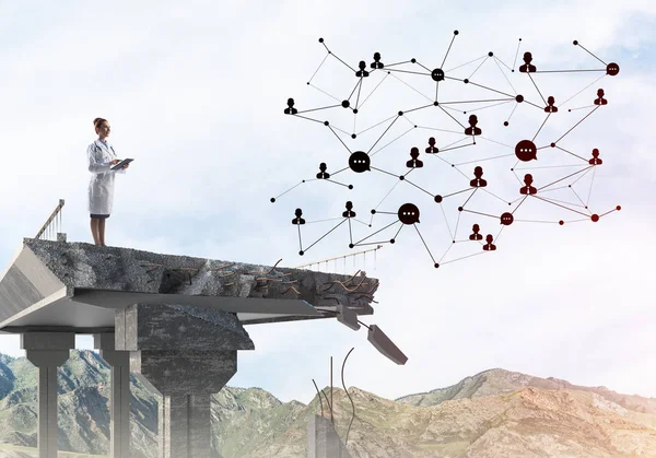 Kırık köprü sonunda beyaz üniforma ayakta genç kadın doktor ve sosyal medya ağ yapısını inceleyerek. Tıbbi endüstri konsepti. Arka planda peyzaj görünümü