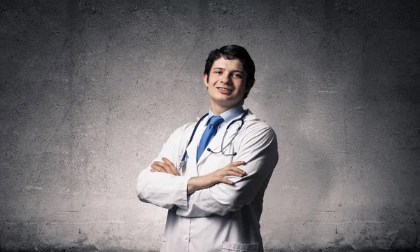 維持腕を交差し 背景に暗い灰色の壁に立っている間カメラを白の医療訴訟の肖像画自信とプロの男性医師 医療業界の従業員のコンセプト — ストック写真