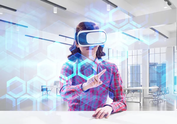 Parlak binanın içinde otururken medya arayüzü ile sanal gerçeklik kulaklık kullanarak damalı gömlek genç kadın yatay çekim. Eğitim süreci için Vr teknolojileri
