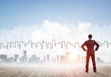 İşadamı arkasını dönüp modern iş merkezinin siluetine bakıyor.