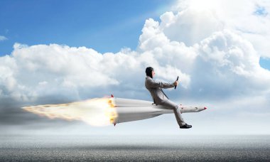 Zemin üzerine mavi bulutlu gökyüzü ile roket yukarıda asfalt yol üzerinde uçan takım elbiseli genç işadamı kavramsal görüntü.