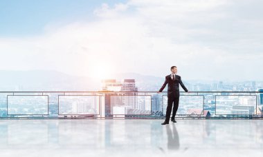 Gökdelenlerin üzerinde gün doğumu ve yeni bir güne bakan iş adamı