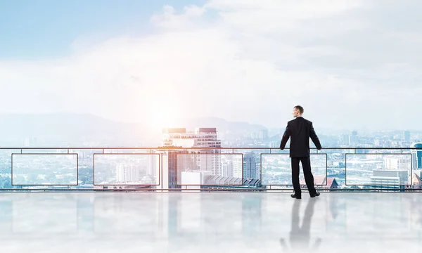 Salida del sol por encima de los rascacielos y hombre de negocios frente a un nuevo día — Foto de Stock