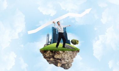 Takım elbiseli genç ve kendine güvenen iş adamının kavramsal görüntüsü büyük beyaz oku elinde tutarken arka planda bulutlu bir gökyüzü ile uçan adada duruyor..