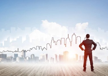 İşadamı arkasını dönüp modern iş merkezinin siluetine bakıyor.