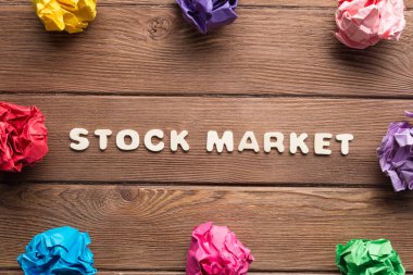 ahşap masa üzerinde daire içinde yerleştirilen renkli kramplı kağıt top