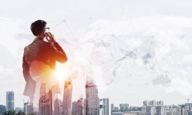 Zarif iş adamının arkası dönük ve cep telefonuyla konuşurken iki kez görüntülenmesi.