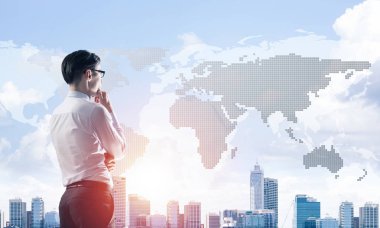 Çenesinde elleri olan genç ve zarif bir iş adamı başka tarafa bakıyor.