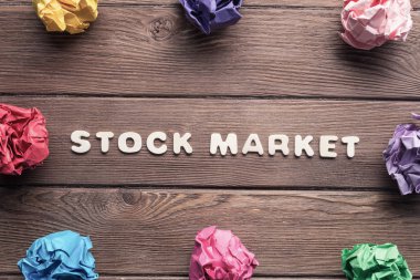 ahşap masa üzerinde daire içinde yerleştirilen renkli kramplı kağıt top