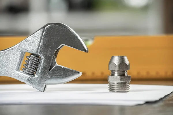 Plumbing pipeline element and adjustable wrench — Stock Photo, Image