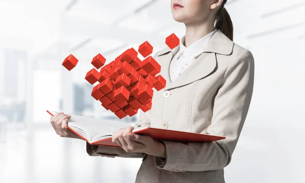 幾何学的な3D赤いキューブ組成を示す女性 デジタル技術とイノベーションソリューション ビジネス管理の概念への新しいアプローチ 薄明かりの中で開かれた本を持つ実業家 — ストック写真