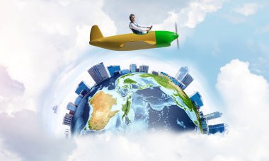 Küçük uçağın kamarasında oturan neşeli genç pilot. Havacı şapkalı, gözlüklü, pervaneli, komik bir adam. Uçakla dünyayı dolaşmak. Dünya küresi bulutlu gökyüzü manzaraları arasında.
