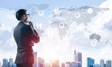 Çenesinde elleri olan genç ve zarif bir iş adamı başka tarafa bakıyor.